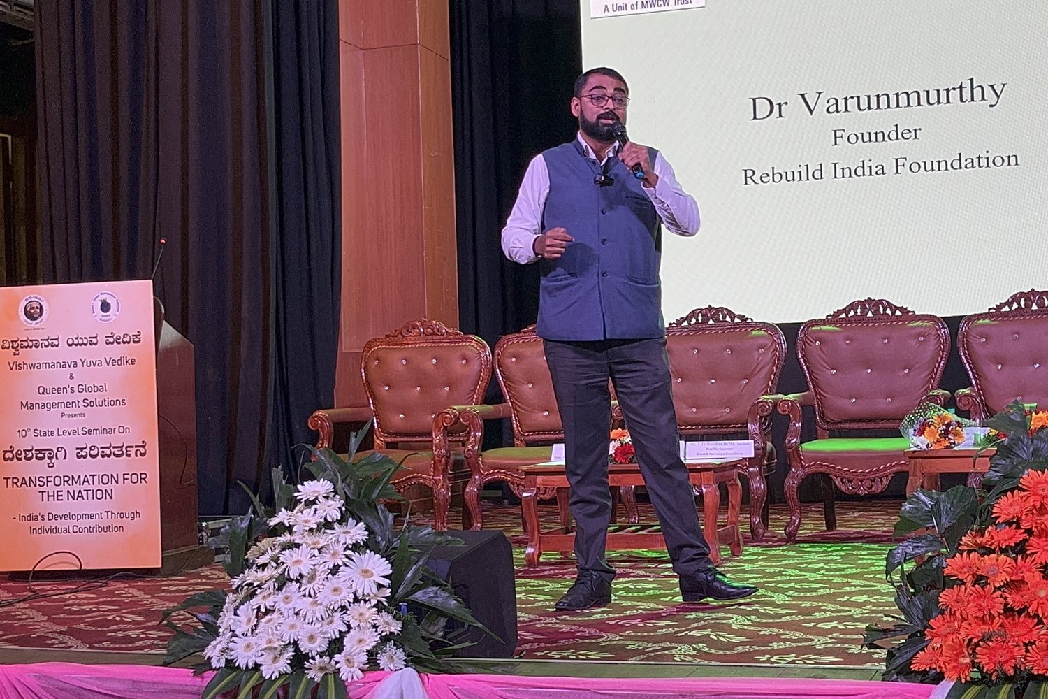The same address — the hall, the dais, the title slide — Dr Varun Murthy